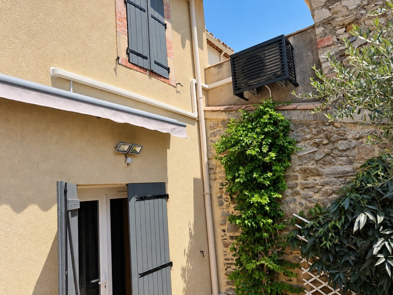 Cache de groupe extérieur · Sur une façade ocre